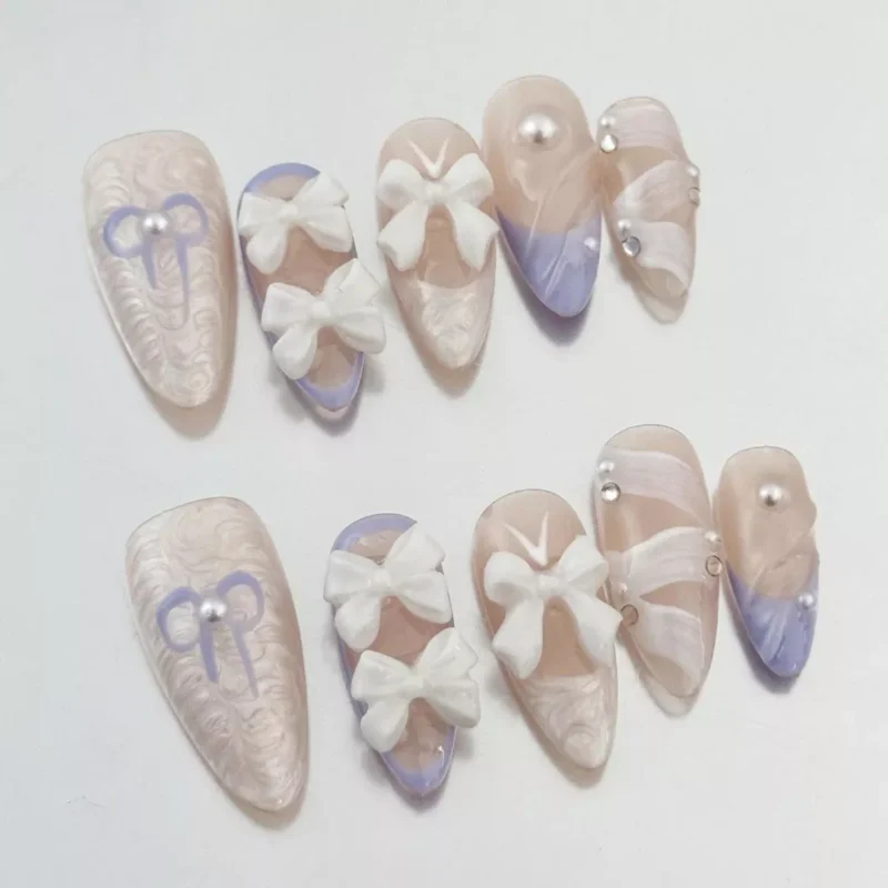 Close-up of White Bow Press-On Nails showcasing sculpted 3D bows and pearl details