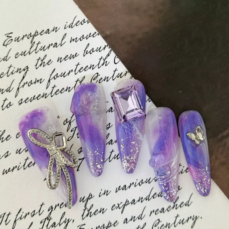 3D charm glitter nails with butterfly and pearl bow accents