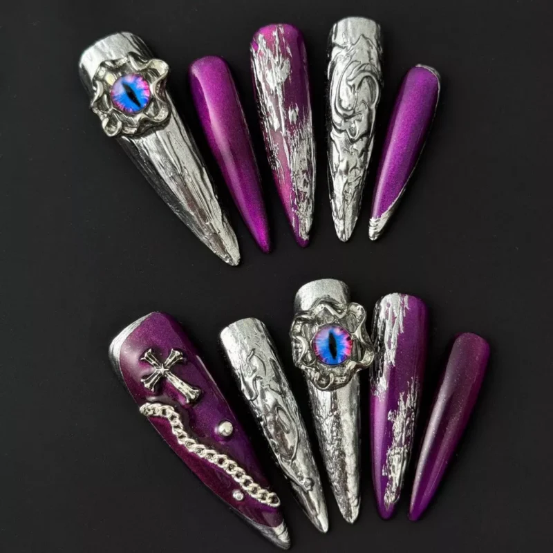 Purple stiletto nail with embedded 3D cat eye jewel and chain detailing