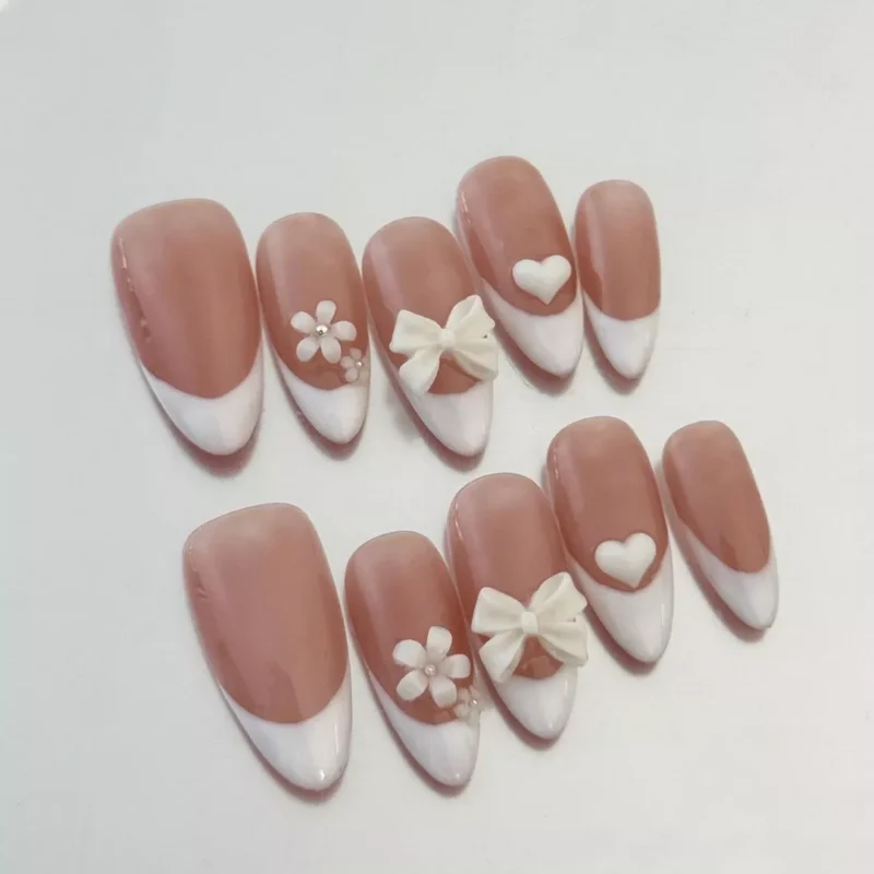Close-up of Nude French Press-On Nails featuring 3D flower and heart charms