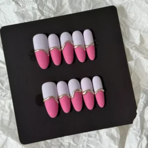 Pink matte press-on nails set featuring dual-tone pink and white base with artistic gold wave accents
