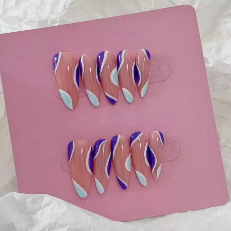 Artistic flat lay of nude base press-on nails with pastel purple and blue designs
