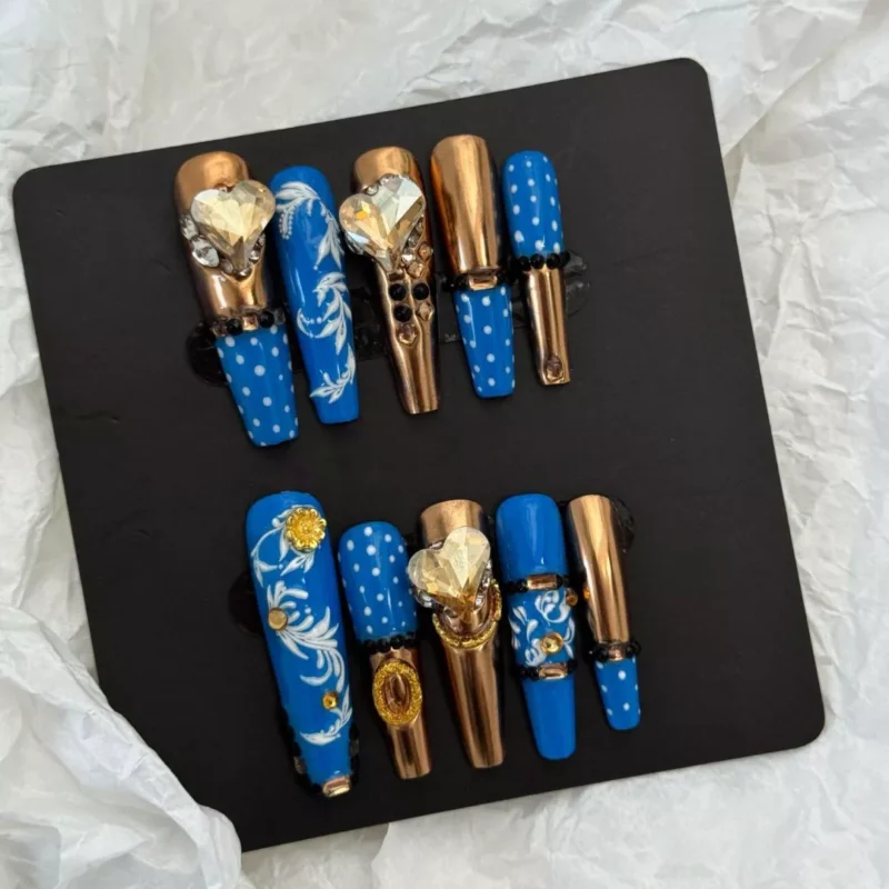 Artistic angle of Royal Blue Press-On Nails displaying gold and crystal embellishments
