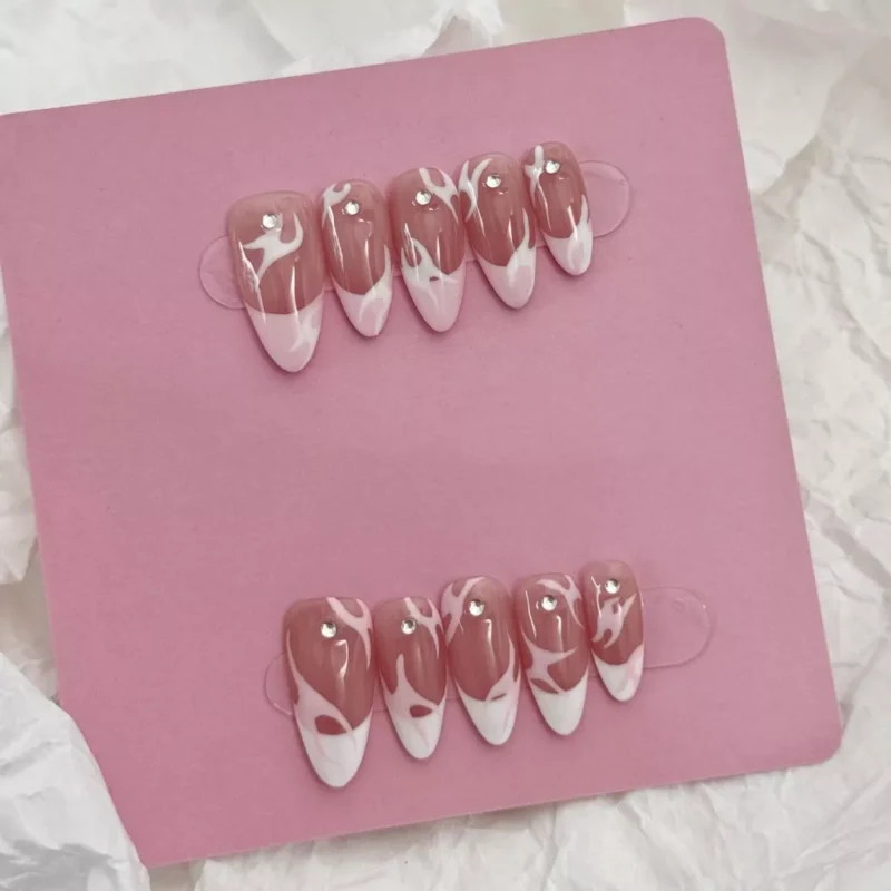 Artistic shot of Pink Flame French Press-On Nails highlighting nude base and pink flame tips