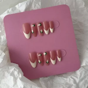 Beige nude press-on nails with elegant white flower details – overhead flat lay