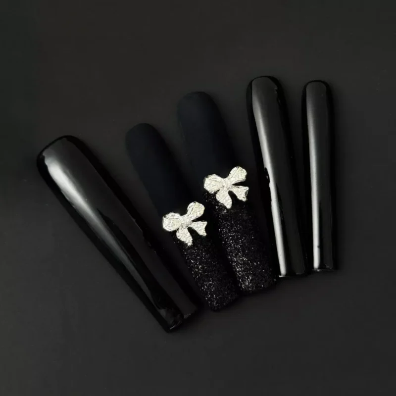 Black press-on nails with matte and glossy finish, glitter bow accents – front display