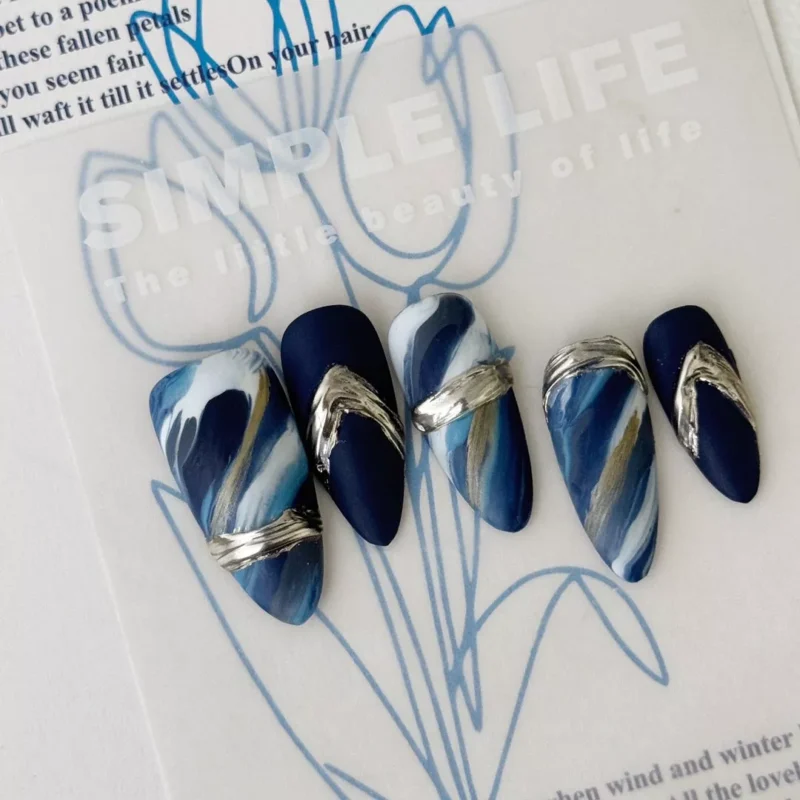 Blue Marble Art Press-On Nails flat lay with artistic elements