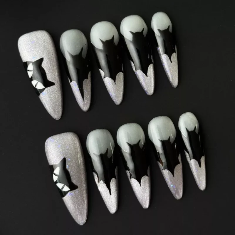 Press-on nail showing black cat silhouette art over silver glitter background