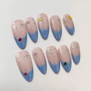 Blue French tip rhinestone nails in coffin shape with celestial gem placement – angled side view