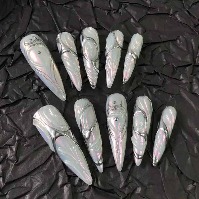 Chrome Swirl White Press-On Nails arranged on crinkled black paper