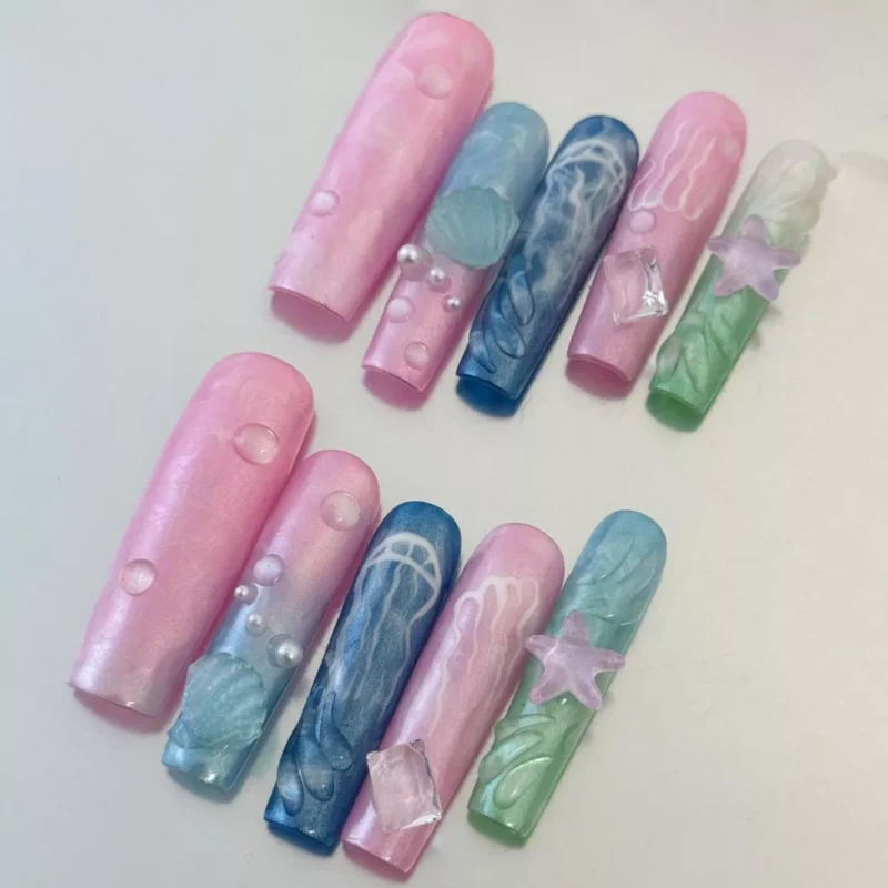 Close-up of Underwater Dream Press-On Nails with pastel jellyfish and seashell textures
