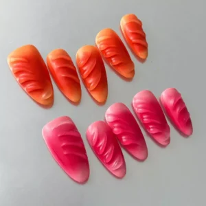 Close-up of Gradient Press-On Nails with vibrant pink to orange ombre and wave details