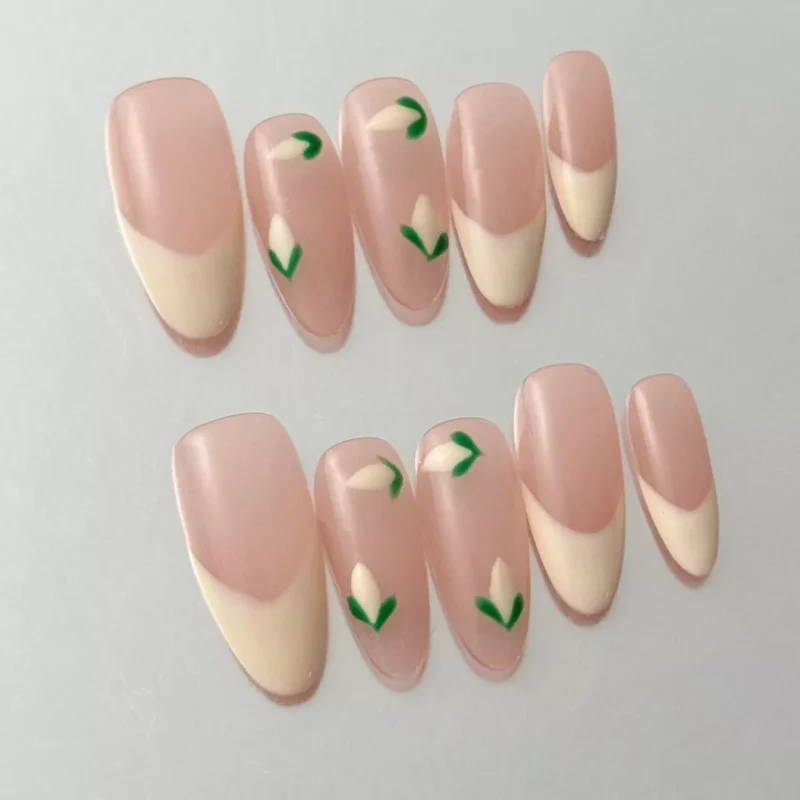 Cream French tip nails with matte nude base and minimal flower art – side angle
