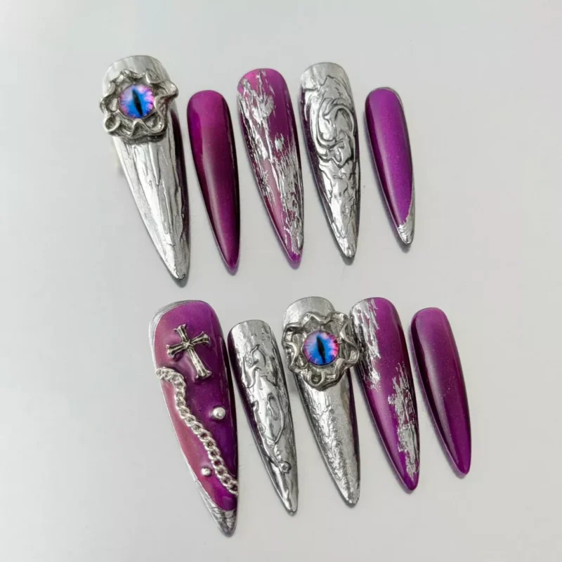 Close-up of stiletto nail with molten chrome and gothic cross accent