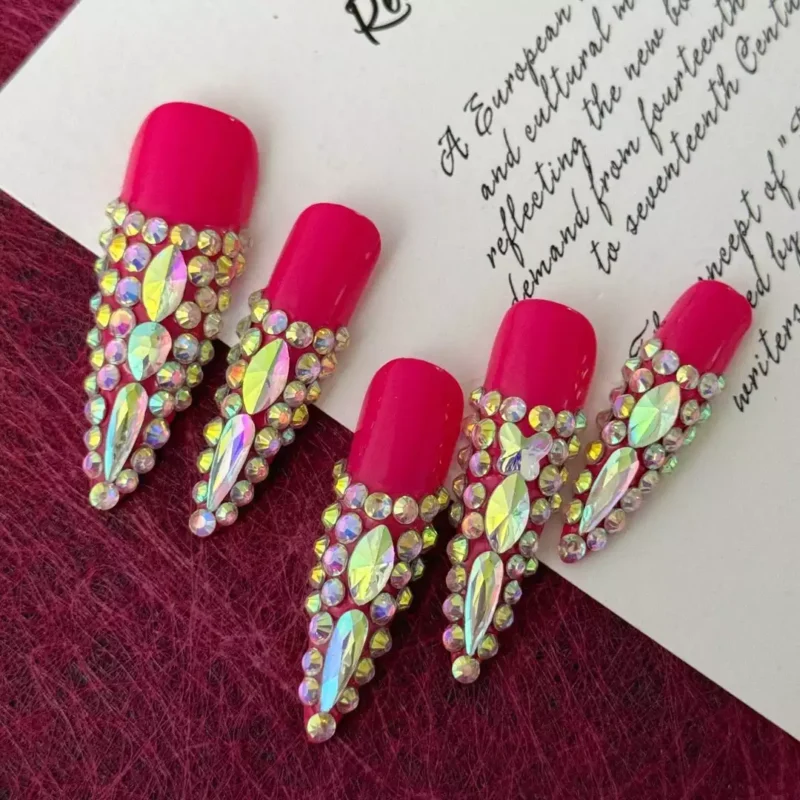 Red Press-On Nails with pointed tips and aurora rhinestone pattern