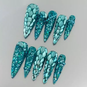 Teal stiletto nails with iridescent rhinestone gradient and glitter base