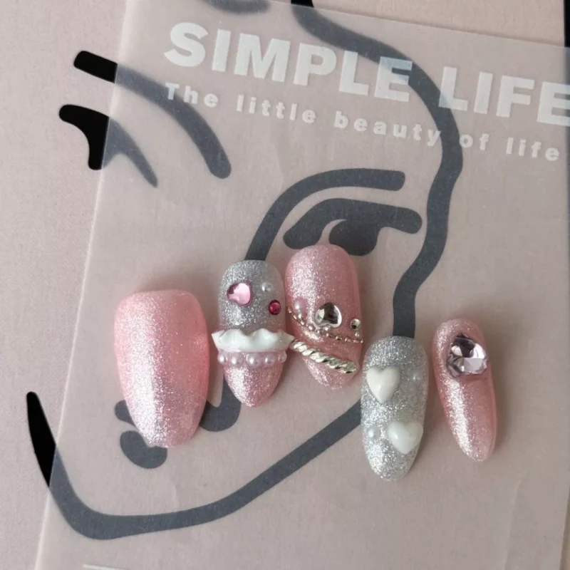 Pink Press-On Nails with frosting and pearls shown in lifestyle scene