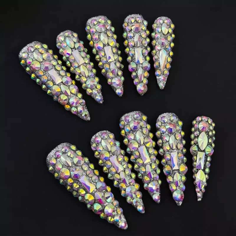 Close-up of iridescent rhinestone press-on nails with sharp stiletto tips