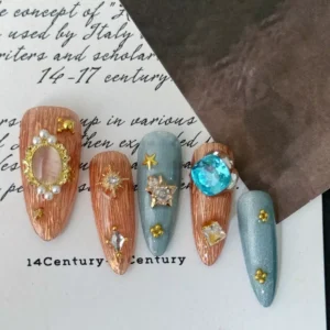Celestial Press-On Nail close-up with heart-shaped blue gem and gold star