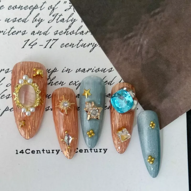 Celestial Press-On Nail close-up with heart-shaped blue gem and gold star