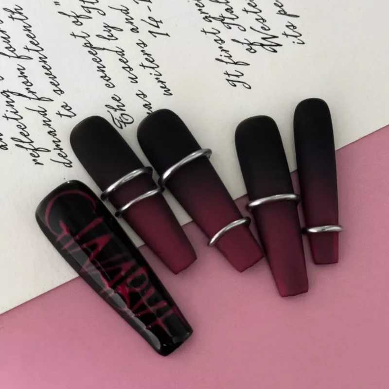 Dark red and black ombre nails with bold square tips and punk text