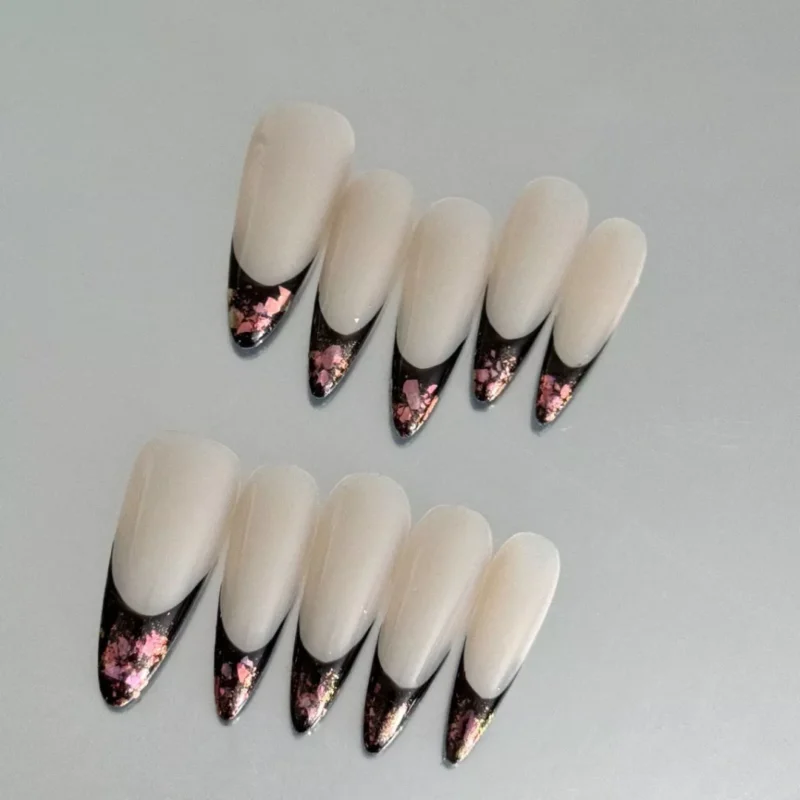 Almond-shaped press-on nails in black and nude with metallic foil