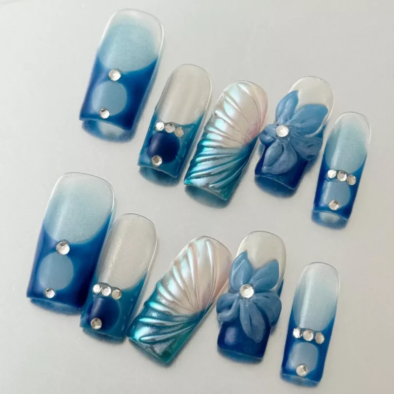 Blue Gradient False Nails with sculpted flower and crystal detail – angled view