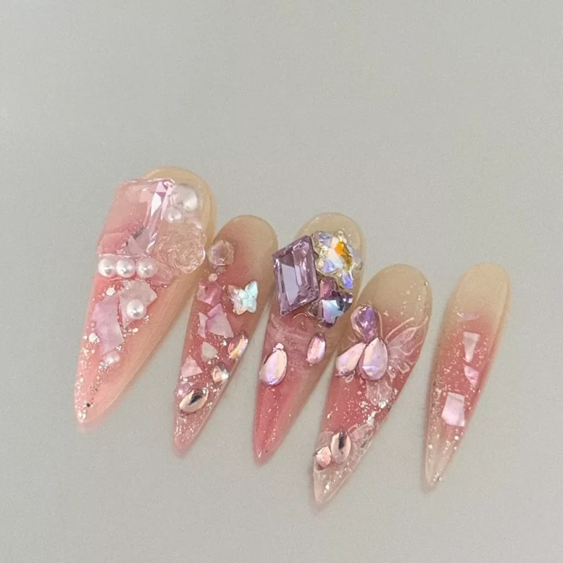 Stiletto nude gradient nails with rhinestone and pearl decorations