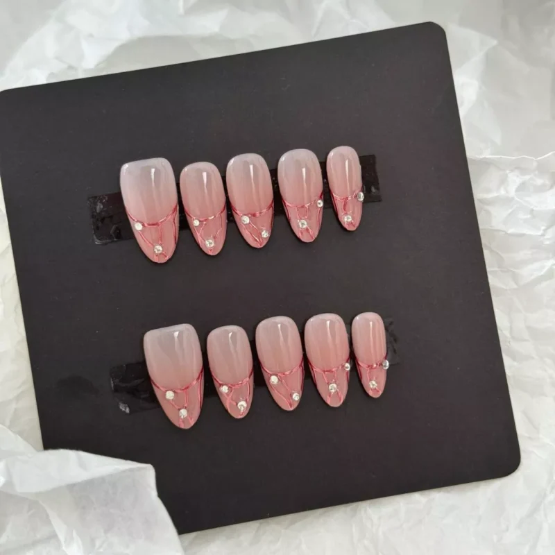 Long coffin nude press-on nails with rose gold chrome veins and elegant rhinestone charm – top-down view
