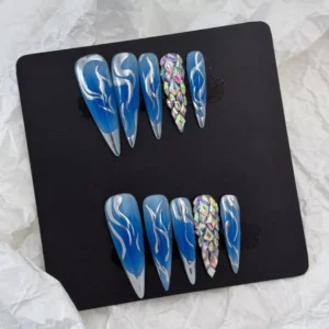 Precision-crafted flames in metallic silver contrast the icy blue background, while faceted rhinestones offer dimensional brilliance and texture.