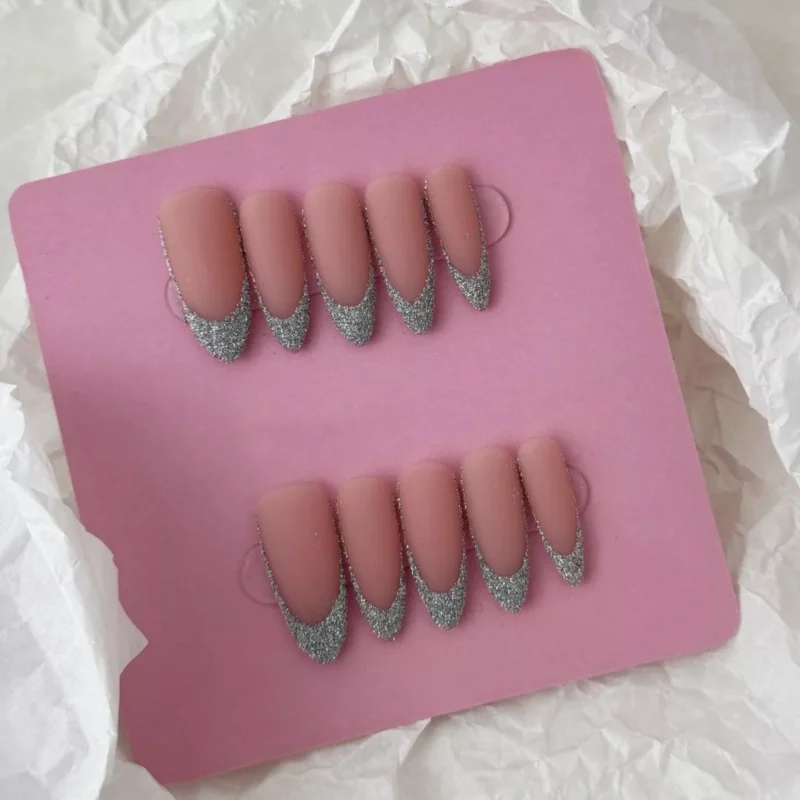 Nude matte press-on nails with silver French tips styled for bridal or formal wear
