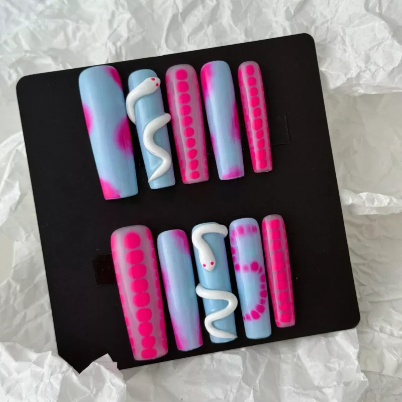 Styled layout of funky press-on nails with 3D snake and dot motifs in pastel tones
