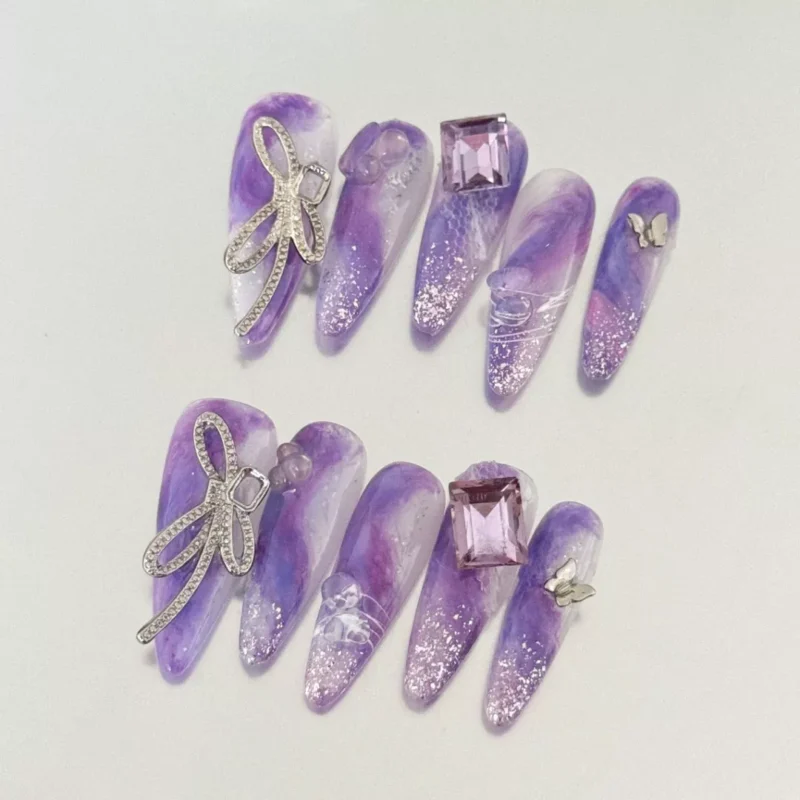 Purple Press-On Nails worn with crystal butterfly accents