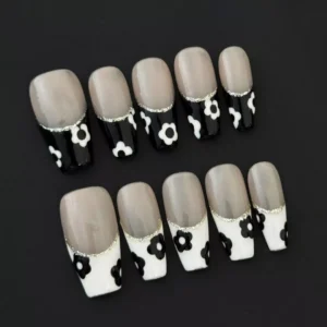 Glitter Trim French Nails featuring black and white blooms on nude background