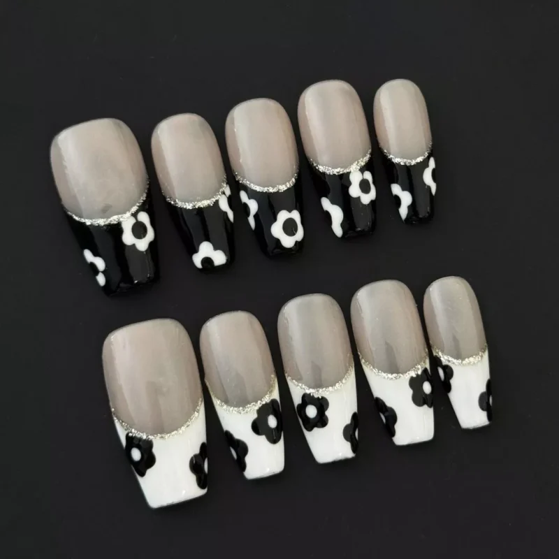 Glitter Trim French Nails featuring black and white blooms on nude background