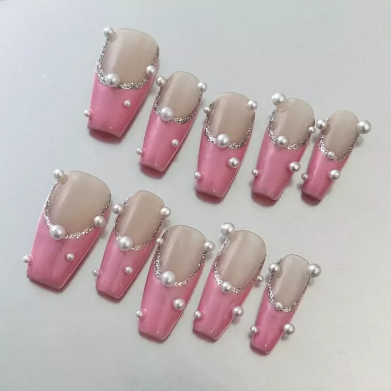 Close-up of Pink Pearl Press-On Nails highlighting glitter French tips and 3D pearls