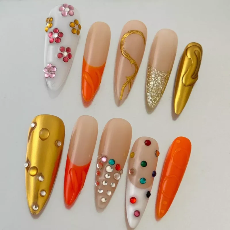 Close-up of gold glitter nail with abstract 3D floral gem cluster