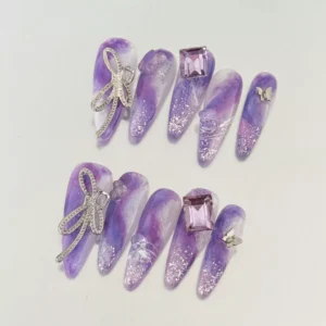 Close-up of glitter tip press-on nails with lavender marble base