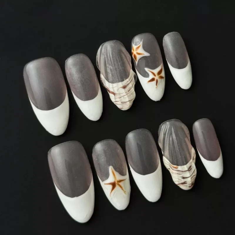 Side angle of neutral French nails with glossy finish and 3D ocean elements