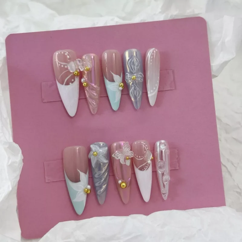Close-up of gold bead accent press-on nails with pastel base and 3D floral elements