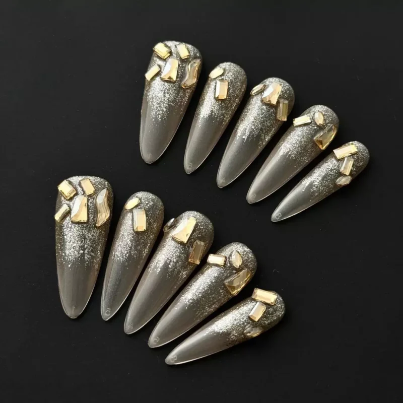 Gold Crystal Shard Press-On Nails on nude glitter gradient background
