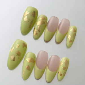 Close-up of almond-shaped green press-on nails with matte texture and metallic gold foil