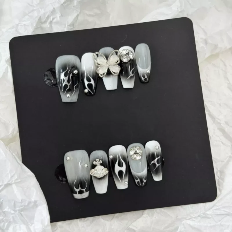 Gothic Flame Nails with dark gradient and star embellishments – flat lay