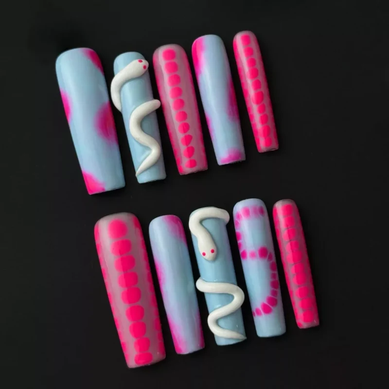 Side view of glossy press-on nail with pink and blue ombré and dot line accents