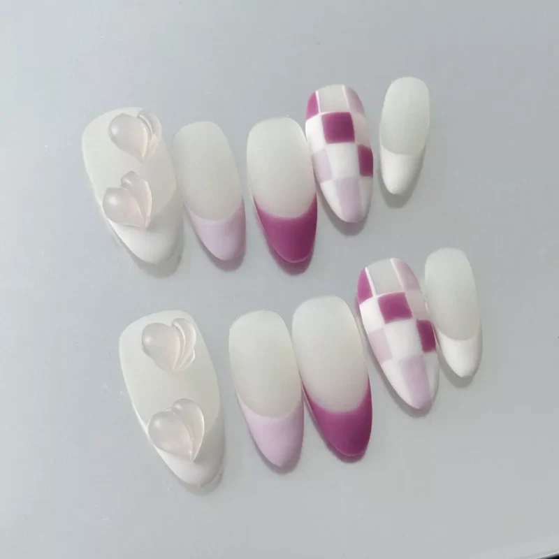 Close-up of matte press-on nail with 3D jelly heart charm and pink and grey color split