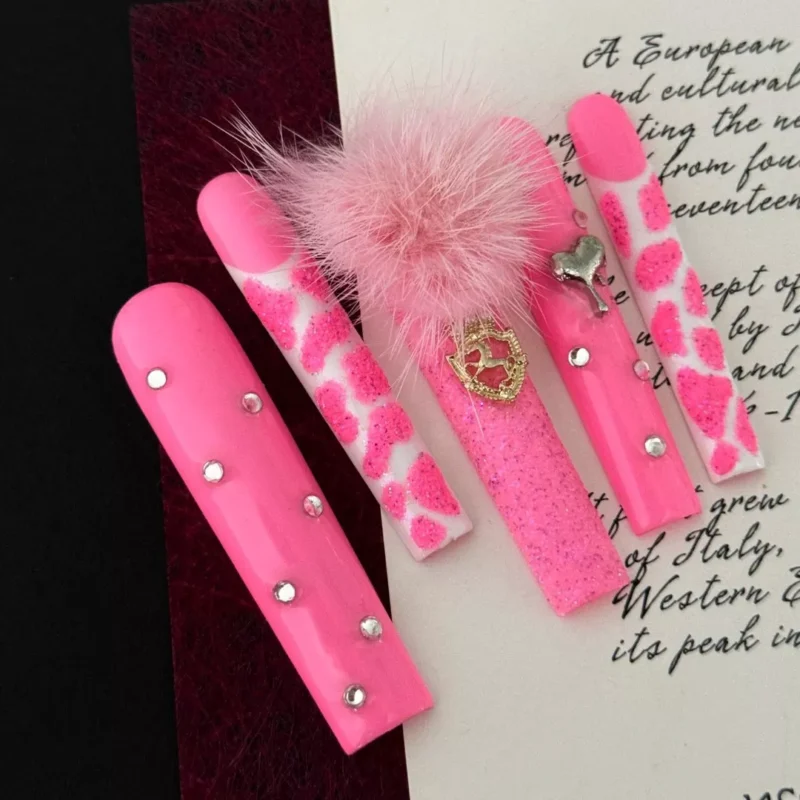 Press-on nails in pink leopard print with glitter and heart embellishments