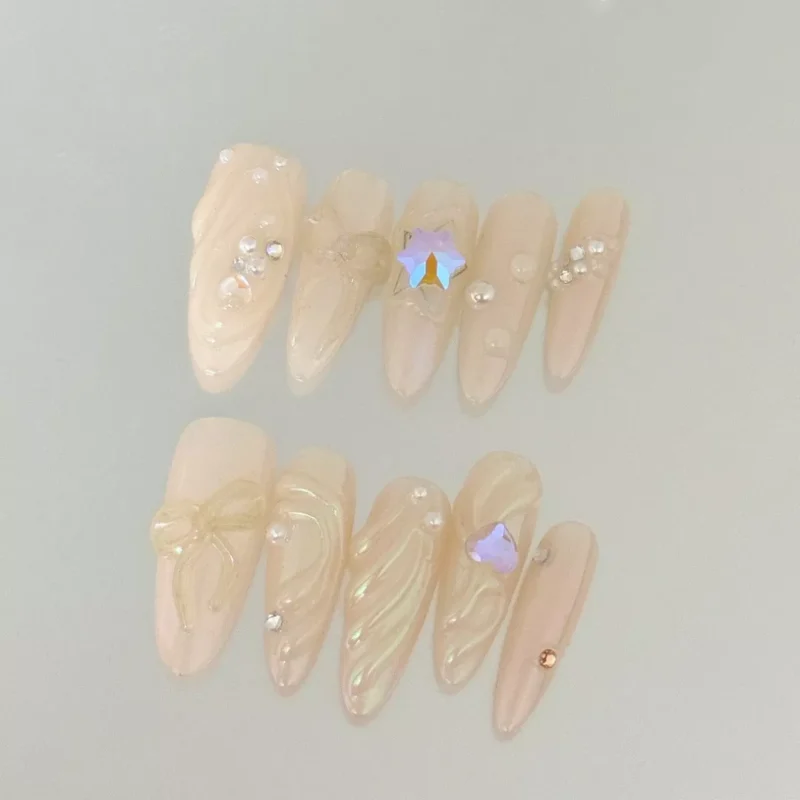 White iridescent press-on nails with pearl finish and crystal bow accents