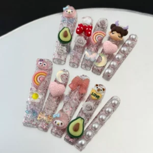 Mixed 3D charm nails with pink, purple, and white heart designs and glossy pearl finish – flat lay style