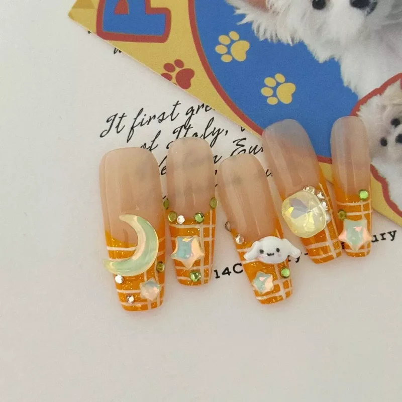 orange press-on nails with 3D stars and cartoon puppy accents
