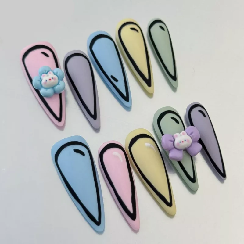 Playful pastel press-on nails with cute cartoon and flower accents